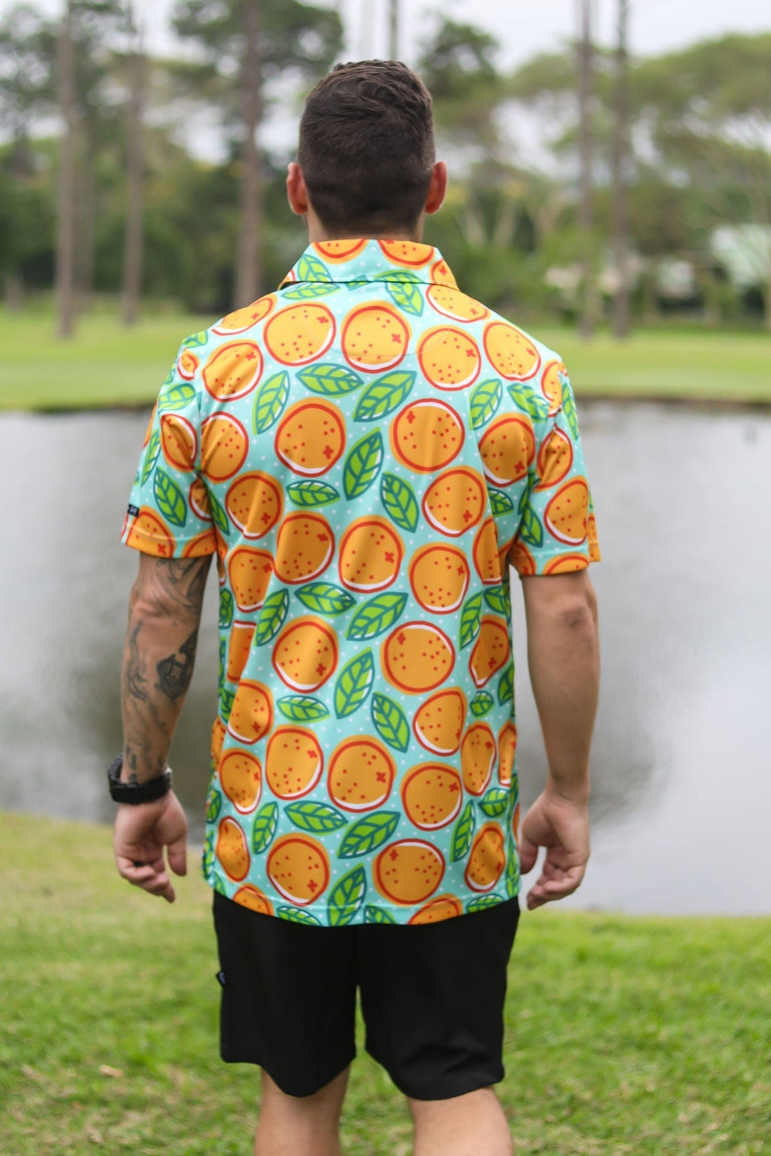 Orange and green citrus fruit patterned shirt with short sleeves.