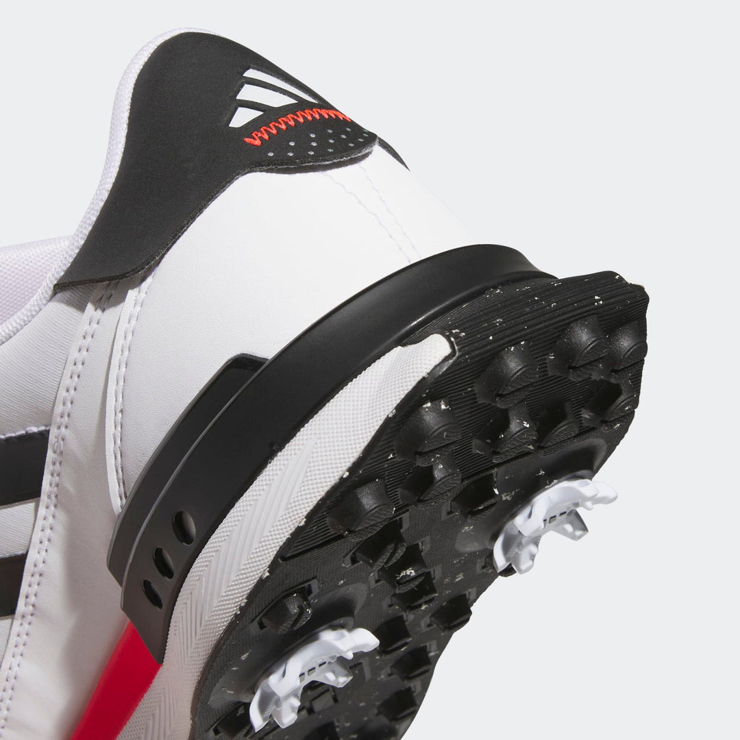 White and black adidas cleat with red accents.