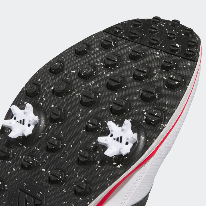 Adidas golf spike shoe with black and white spikes, red accents.