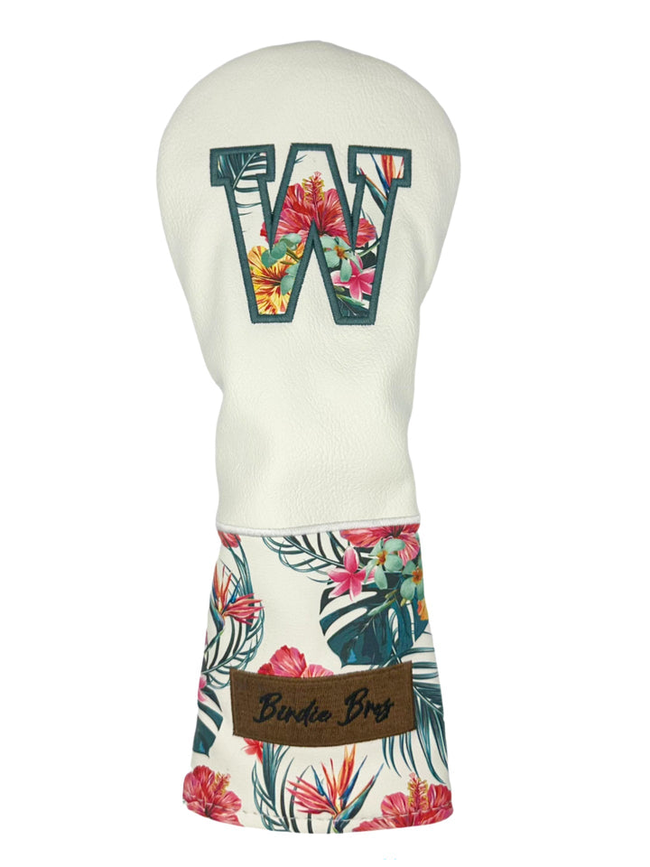 White floral golf club head cover with green letter ’w’ and brown label.