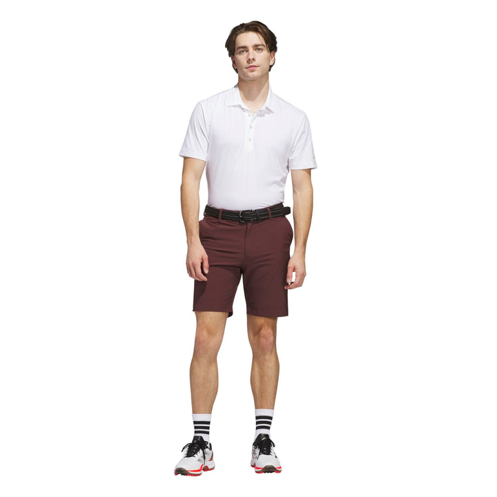 Maroon golf shorts with white polo shirt and black belt, adidas brand.