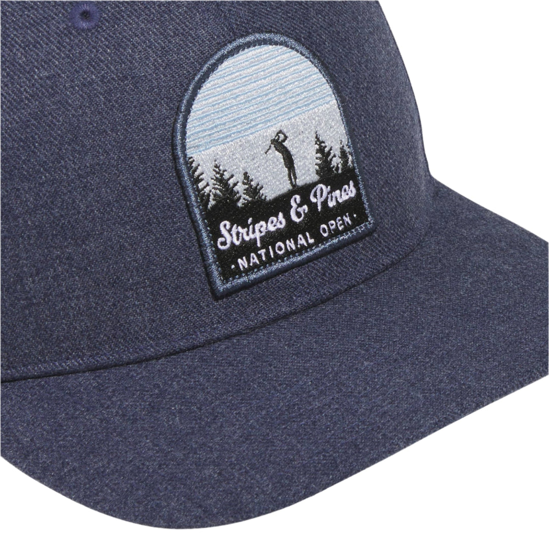 Navy blue baseball cap with ’stripes & pines national open’ patch featuring a pine tree and golfer silhouette.