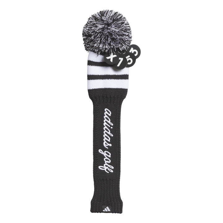 Black and white adidas golf club head cover with pom-pom design.