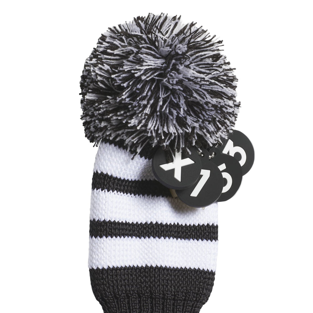 Black and white striped knit golf club head cover with pom-pom accent.