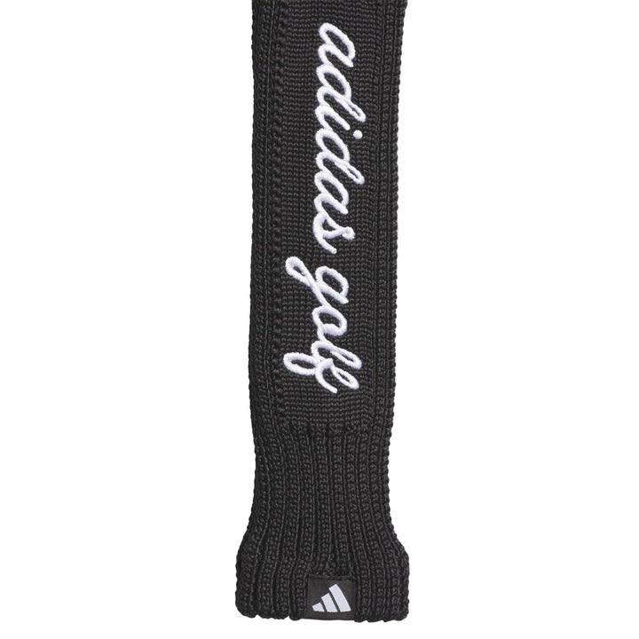 Black adidas golf club head cover with white logo and text.