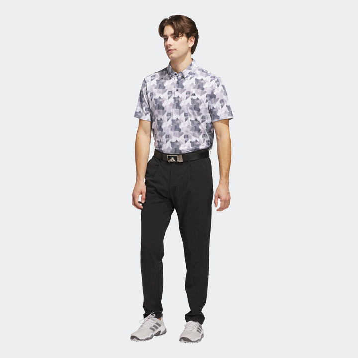 Short-sleeved golf shirt with a floral pattern in white and gray on black background, made of polyester material.