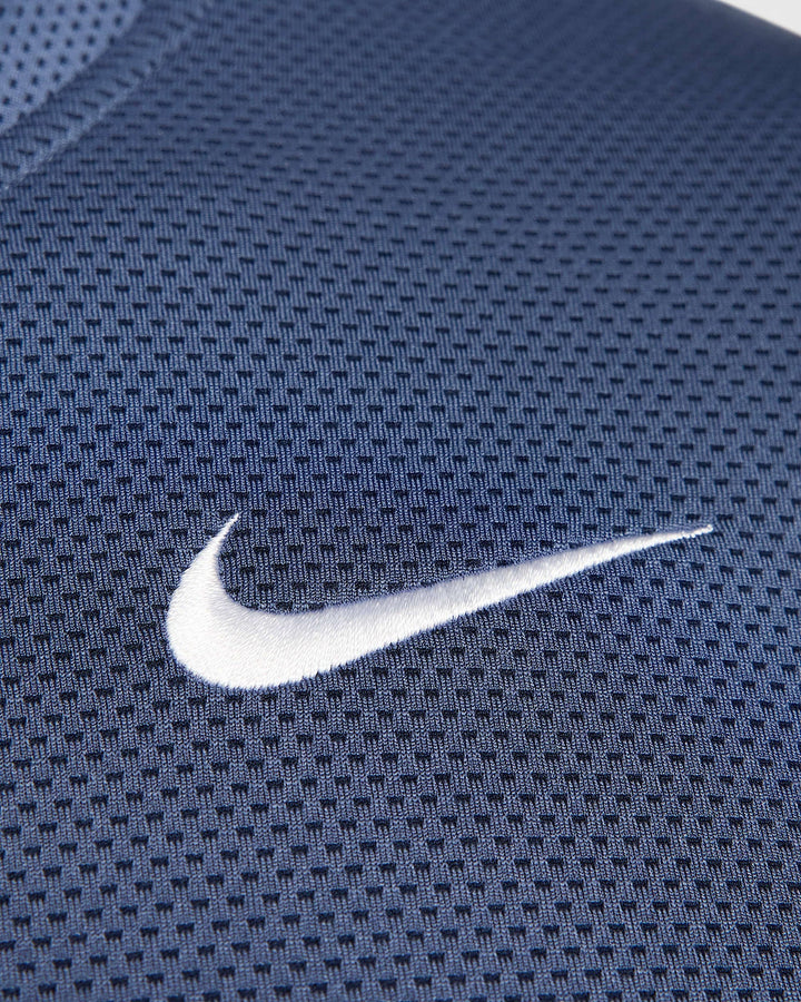 Nike swoosh on navy blue mesh fabric.