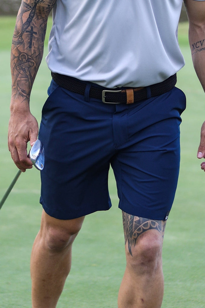Blue golf shorts with black belt and white shirt.