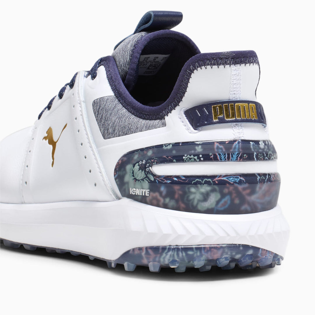 White and navy blue puma ignite golf shoe with floral design on the sole.
