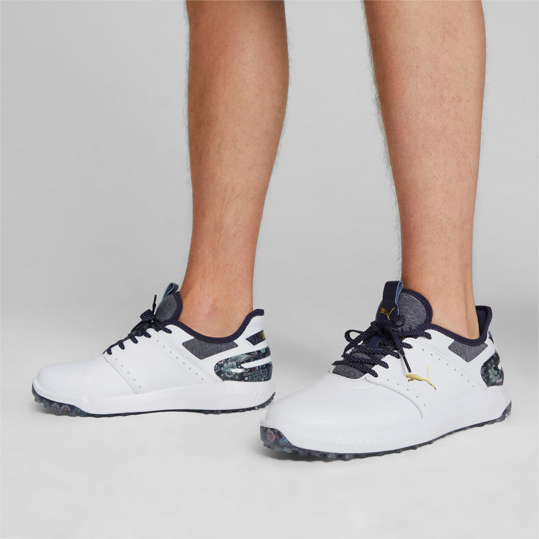 White and black golf shoes with textured soles, designed for grip.