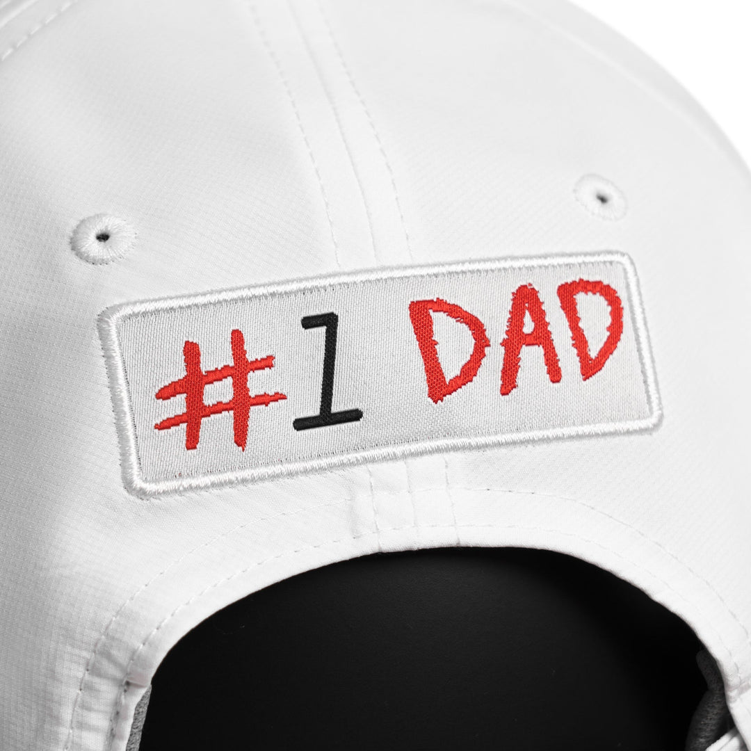 White baseball cap with ’#1 dad’ patch in red and black design.