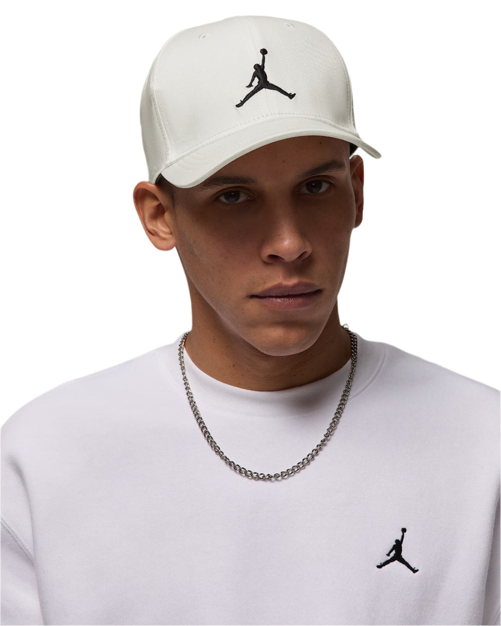 White jordan cap with black logo and chain necklace.