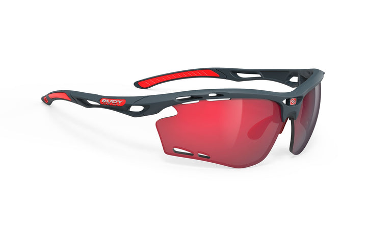 Red and black sunglasses with a glossy finish, featuring the brand name ’rudy project’ on the frame.